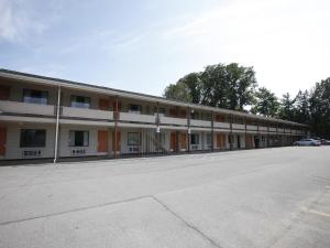 un aparcamiento vacío frente a un edificio en Scottish Inns Albany, en Albany