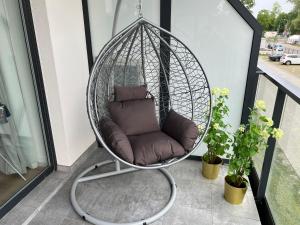 a hanging chair with a cushion on a balcony at Baltic Nest - Dziwnów in Dziwnów