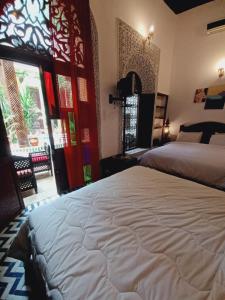 een slaapkamer met een groot bed en een raam bij Palais Al Firdaous in Fès