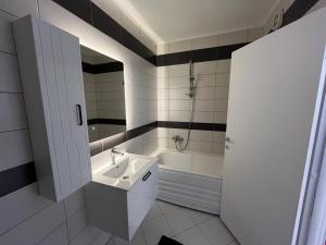 a bathroom with a sink and a bath tub at Skyline Serenity Apartment in Prizren +12 photos