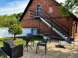 - une terrasse avec des chaises et un escalier dans un bâtiment en briques dans l'établissement Las Palmas, à Bysławek