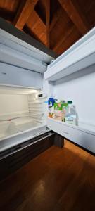 un frigorifero vuoto con la porta aperta con il cibo all'interno di B&B Audrey a Varese