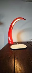 una lampada rossa seduta sopra un tavolo di legno di B&B Audrey a Varese