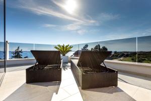 - deux chaises sur un balcon avec vue sur l'océan dans l'établissement Seaside residence - Sunset Appartement, à Kožino