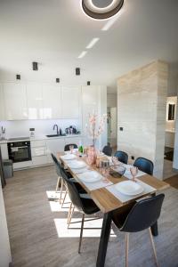 un tavolo da pranzo con sedie e una cucina di Seaside residence - Sunset Appartement a Kožino