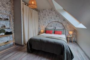 a bedroom with a bed with red and blue pillows at Douceur d'Eden in Camaret-sur-Mer +20 photos