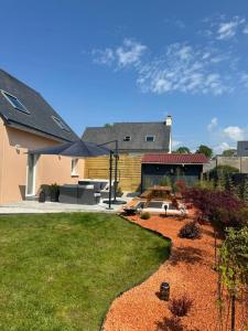 a yard with a house with a large umbrella at Douceur d'Eden in Camaret-sur-Mer