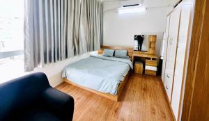 - une petite chambre avec un lit et une chaise dans l'établissement Phuc Khang Apartment, à Hô-Chi-Minh-Ville