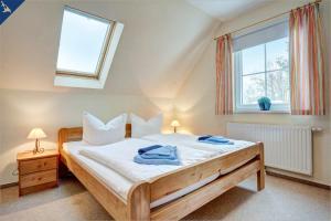 - une chambre avec un lit et 2 serviettes dans l'établissement Villen am See - 4-Raum Häuser DHH See- Idyll 2, à Korswandt