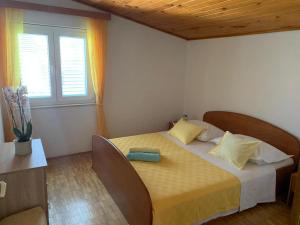 ein Schlafzimmer mit einem Bett in einem Zimmer mit einem Fenster in der Unterkunft Captain's House in Baška Voda
