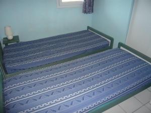 2 camas en una habitación con paredes azules en Appartement Le Grau-du-Roi, 3 pièces, 6 personnes - FR-1-731-63, en Le Grau-du-Roi