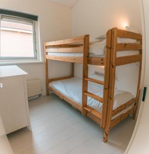 two bunk beds in a small room with a window at Rekerlanden 275 in Warmenhuizen