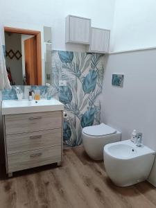 a bathroom with a sink and a toilet and a mirror at Appartamento Luisa E in Villasimius +39 photos