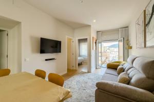 a living room with a couch and a tv at Barcelona Amelie Apartment in Hospitalet de Llobregat