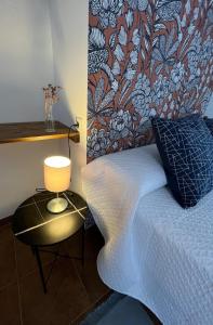 1 dormitorio con 1 cama y 1 mesa con lámpara en Alojamiento La Escalera, en Alhama de Granada