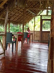 uma sala de jantar com mesas e cadeiras num pavilhão em River Spot Lodge em Tena