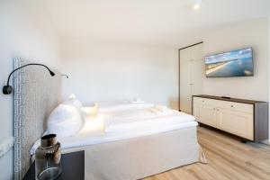 um quarto branco com uma cama e uma cómoda em Villa Albus App 7 em Ahlbeck