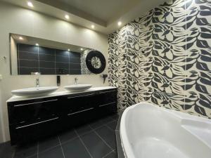 a bathroom with two sinks and a large mirror at Luxury view apartment 10min from Athens airport in Koropíon