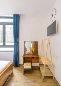 a bedroom with a desk and a mirror at VX Hotel in Da Lat