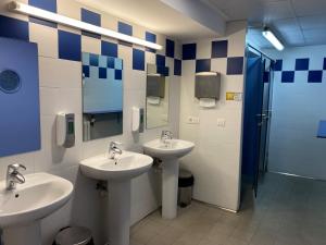 La salle de bains est pourvue de 2 lavabos et d'une douche. dans l'établissement Albergue de Villava, à Villava