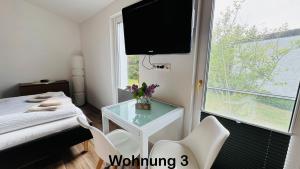 a bedroom with a tv and a table and chairs at Ferienwohnung Felix in Templin