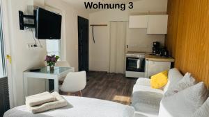 a living room with a white couch and a kitchen at Ferienwohnung Felix in Templin