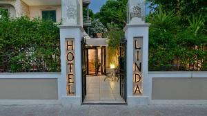 een poort naar een huis met een bordje met de tekst welkom bij Hotel & Apartments Villa Linda in Giardini Naxos
