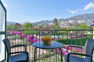 a table with a basket of fruit on a balcony at Hotel & Apartments Villa Linda in Giardini Naxos