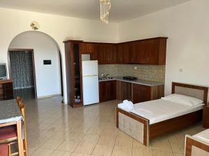 a kitchen with a bed and a white refrigerator at Villa AlMar in Sarandë