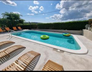 una piscina con 3 sillas y una piscina en Sweet room with a terrace, en Roč