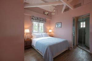 una camera da letto con un letto, due lampade e una finestra di Kyparissia Old Town Home Collection! a Kyparissia