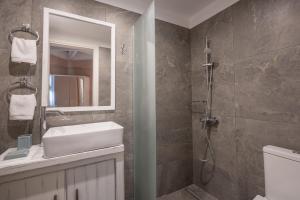 un bagno con doccia, lavandino e specchio di Kyparissia Old Town Home Collection! a Kyparissia Altre 77 foto
