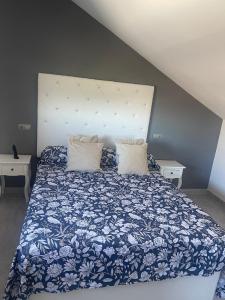 ein Schlafzimmer mit einem blau-weißen Bett mit Kissen in der Unterkunft Villa Rosa in Peñíscola
