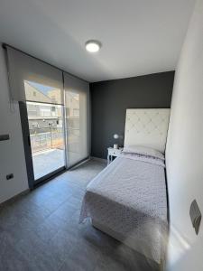 ein Schlafzimmer mit einem Bett und einem großen Fenster in der Unterkunft Villa Rosa in Peñíscola