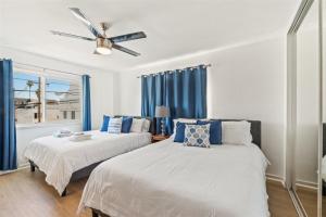 two beds in a room with blue curtains at 104-unit 4 in San Diego