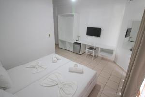 a white room with a bed and a television at Hotel Ceka in Sarandë