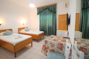 a hotel room with two beds and a television at Hotel Ceka in Sarandë