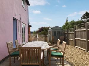 a wooden table and chairs on a patio at Woodbrook Cottage in Bridport