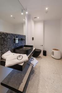 a bathroom with a black sink and a toilet at Gialova Hills Luxury Villas with Private Pool in Gialova