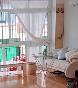 ein Wohnzimmer mit einem Sofa und einem Glastisch in der Unterkunft Playa Beach Malaga 3habts dobles, cocina familiar, apartamento completo in La Cala del Moral