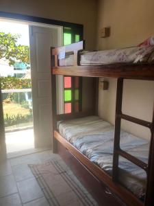 two bunk beds in a room with a window at Felicidade in front sea in Saquarema