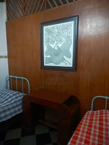 a bedroom with a table and a picture on the wall at Hostel Vasantashram CST Mumbai in Mumbai