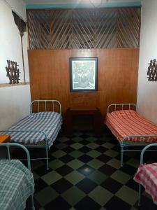 um quarto com duas cadeiras e um piso xadrez em Hostel Vasantashram CST Mumbai em Mumbai