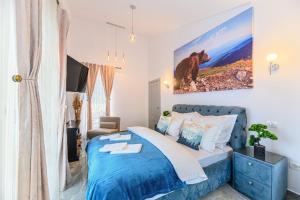 a bedroom with a blue bed with a bear painting on the wall at AYASI Luxury Apartment Predeal in Predeal