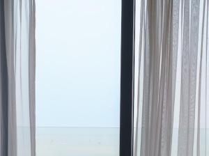 una finestra con tende bianche in una stanza di Hải Tiến a Thanh Hóa Altre 11 foto