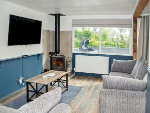 a living room with a tv and a fireplace at Acre Hill Lodge in Harrop Fold