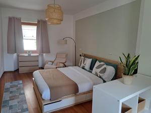 a bedroom with a bed and a chair and a window at Ermele's Green House in Borgosesia