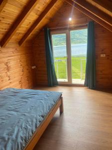 sypialnia z łóżkiem i dużym oknem w obiekcie Begov kamp, Plav w mieście Plav