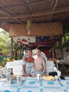 een man en een vrouw aan een tafel bij 8 Star Paradise in Locaroc