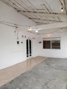 an empty room with white walls and lights at Rumah Pemandangan Lembah & Pegunungan tepi Jalan Raya in Banyumas